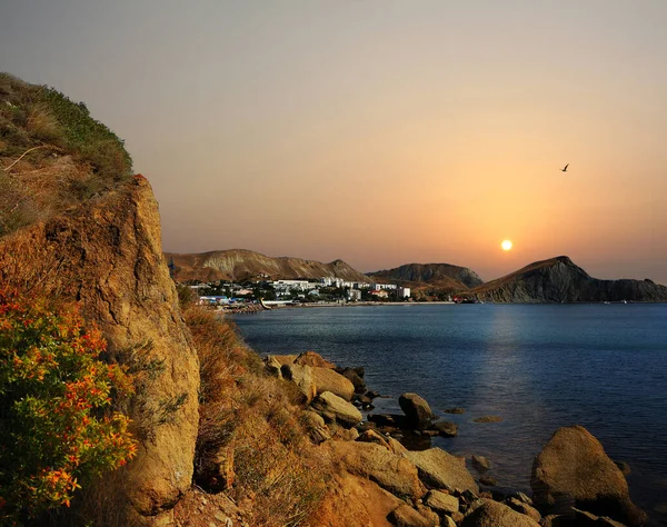 Karadağ 'ın doğu kıyısında, Kırım' ın doğu kıyısında pitoresk bir günbatımı. Güneş Karadeniz 'in üzerinde ve Koktebel yakınlarındaki Doğu Kırım' daki Karadağ sıradağlarının üzerinde batıyor.. 