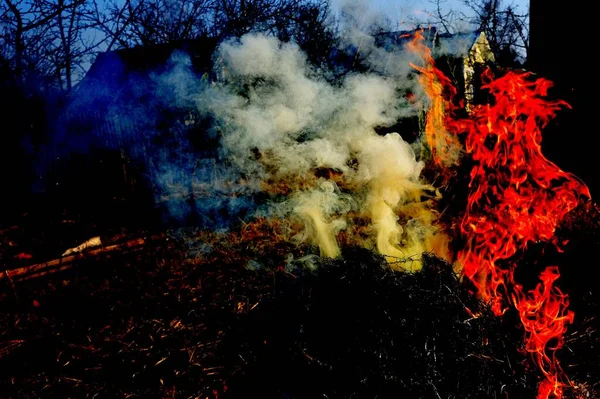 Ateşin Doğuşu. Şenlik ateşinin yakıldığı an. Ateş dumandan yükselir. Ateş, dallardan tutuşturulmuştur. Şehrin dışında.