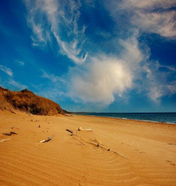 Kum dalgaları, Karadeniz 'in kumlu kıyıları, Doğu Kırım. Kum dalgalarının güzel deseni. Uzakta Karadeniz 'in masmavi sularını ve dağlık kıyı şeridini görebilirsiniz. Gök mavisi gökyüzünde yaz bulutları. Huzur ve sükunet 