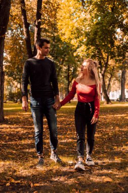  Bir adam ve aşık bir kız sonbahar parkında el ele tutuşuyorlar.