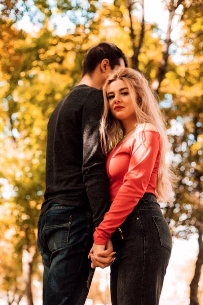 Pareja cariñosa abrazando puestos en el parque de otoño —  Fotos de Stock