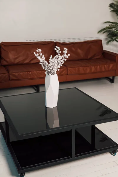 Su un tavolo di vetro nero è un vaso bianco di fiori in ufficio — Foto Stock