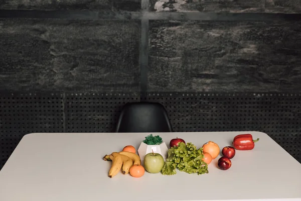 Τα λαχανικά και τα φρούτα είναι σε λευκό τραπέζι. — Φωτογραφία Αρχείου