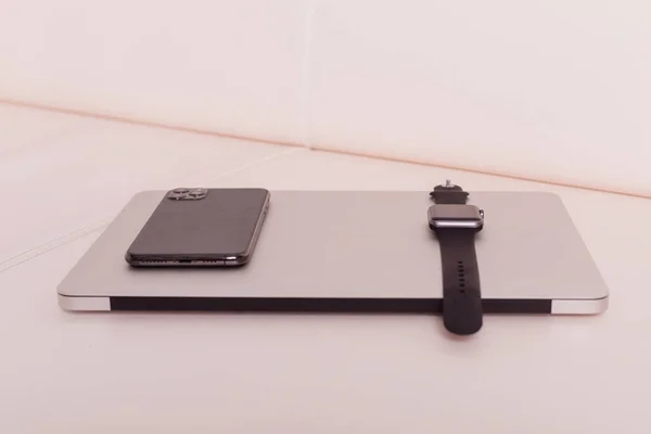 Telefon a hodinky jsou nahoře na notebooku — Stock fotografie