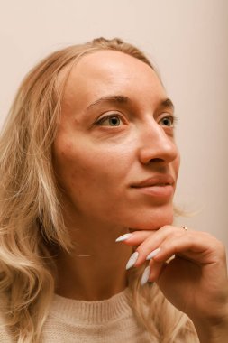 Eline yaslanan genç bir kadın gülümsüyor.