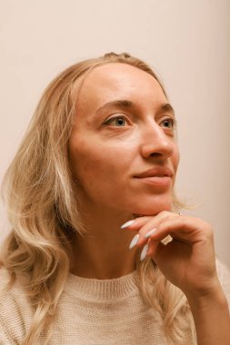 Eline yaslanan genç bir kadın gülümsüyor.