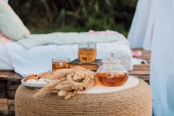 Na mesa de madeira há xícaras de chá, uma chaleira, um livro e flores secas. — Fotografia de Stock