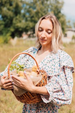 Genç ve güzel bir kız elinde ördek yavrusuyla bir sepet tutuyor.