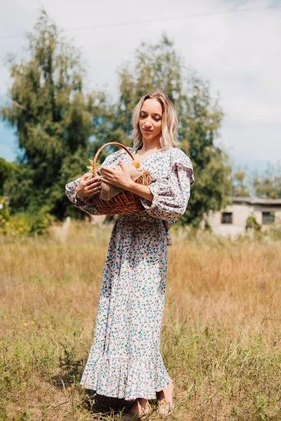 Genç ve güzel bir kız elinde ördek yavrusuyla bir sepet tutuyor.