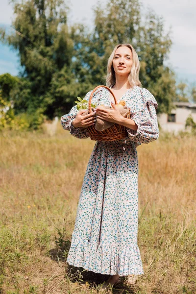 Genç ve güzel bir kız elinde ördek yavrusuyla bir sepet tutuyor.