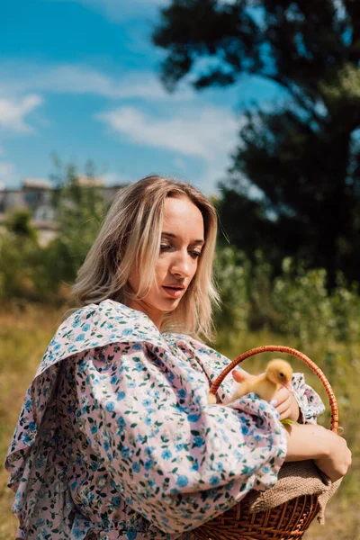 시골 지역에 사는 한 소녀 가손에 오리를 들고 바구니를 들고 있다 — 스톡 사진