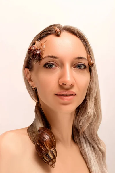 Stora och små sniglar av achatina krypa på ansikte och hals av en ung flicka — Stockfoto