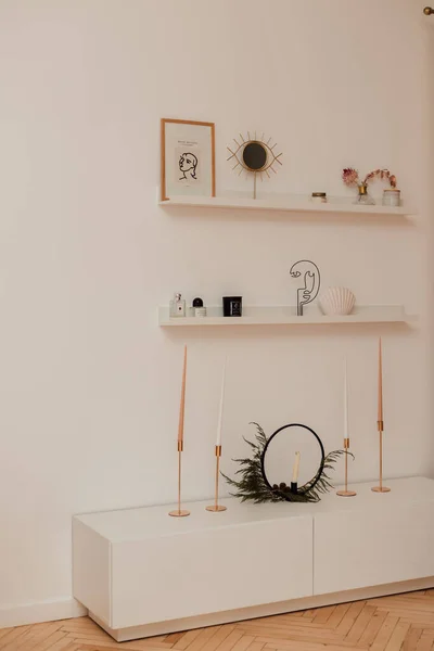 Candles, a picture, a mirror stand on white shelves against the wall — Foto Stock