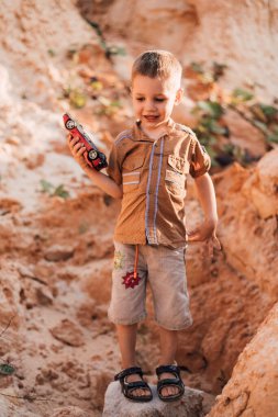 Küçük mutlu bir çocuk elinde bir daktilo tutuyor, gülümsüyor ve aşağıya bakıyor.