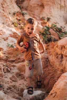 Küçük mutlu bir çocuk elinde bir daktilo tutuyor, gülümsüyor ve aşağıya bakıyor.