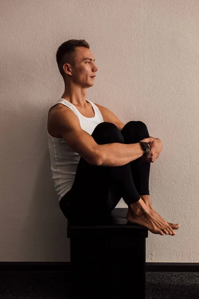 A man doing yoga holds his legs with his hands — стоковое фото