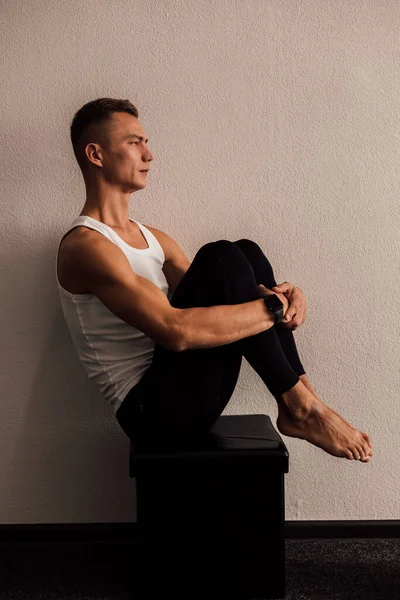 A man doing yoga holds his legs with his hands — стоковое фото