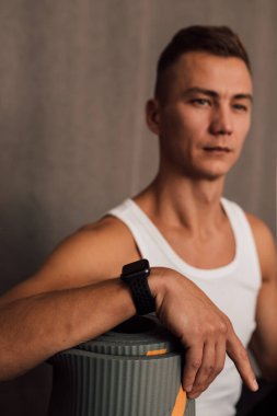 Spor eğitimi için bir erkeğin eli paspasın üzerinde dinlenir.