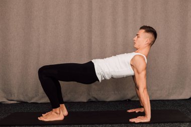 Genç ve yakışıklı bir sporcu bir barda duruyor.