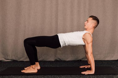 Genç ve yakışıklı bir sporcu bir barda duruyor.