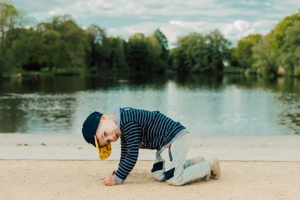 Güneşli bir günde, küçük bir çocuk nehir kenarında oynar