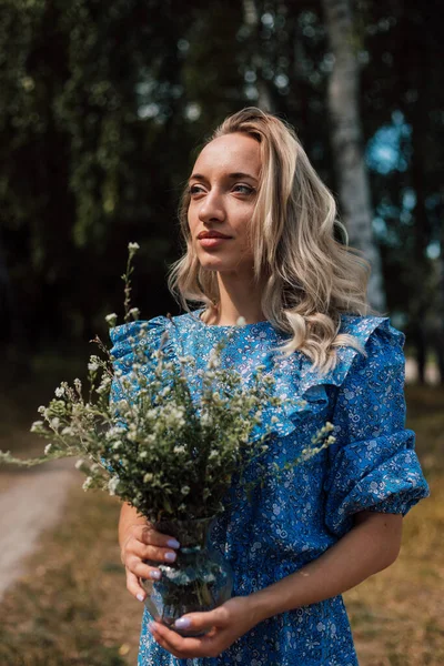 Uma Jovem Mulher Bonita Vestido Azul Segura Flores Selvagens Suas — Fotografia de Stock