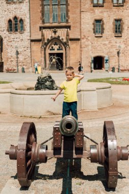 Güneşli sıcak bir gün. Çocuk silahın üstüne oturdu ve güldü.