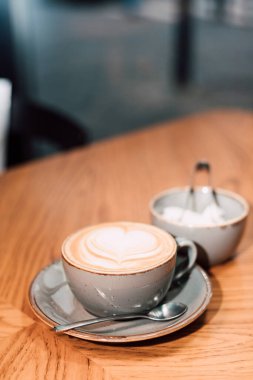 Bir fincan kapuçino ve ahşap bir masanın üzerinde pişmiş şeker. Yüksek kalite fotoğraf