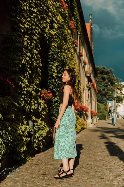 Genç ve çekici bir kadın kilisenin yakınındaki eski bir caddede yürüyor. Yüksek kalite fotoğraf