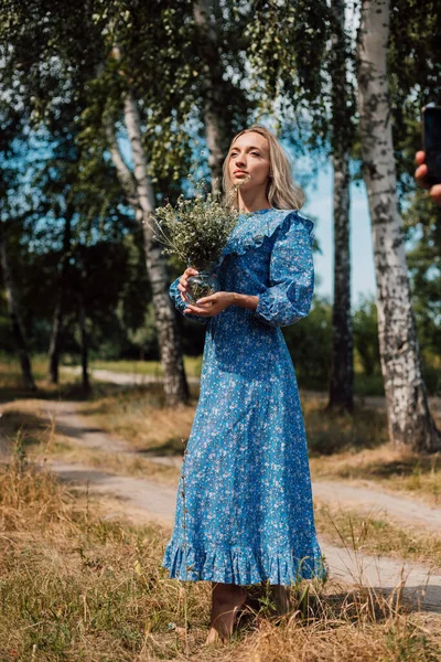 Una Joven Mujer Hermosa Con Vestido Azul Sostiene Flores Silvestres — Foto de Stock