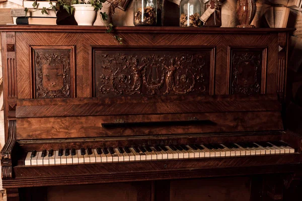 An old piano in a dark room. Lots of books on the walls. High quality photo