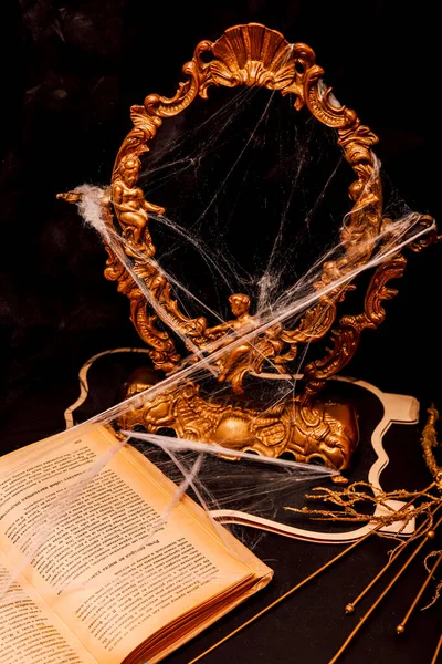 Halloween book composition, spider web, old vintage frame on a black background. High quality photo