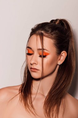 Kız gözlerini kapattı, gözleri kırmızı gölgelerle boyandı. Güzel, parlak makyajlı güzel bir kızın portresi. Yüksek kalite fotoğraf