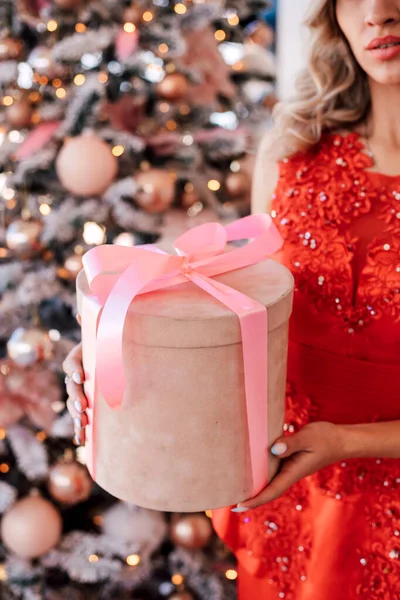 Pink box with a gift in the hands of a girl New Year. High quality photo