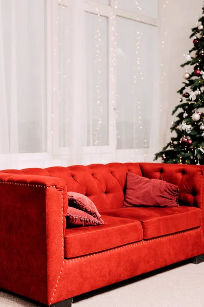 Κόκκινο Μοντέρνο Καναπέ Δίπλα Στο Χριστουγεννιάτικο Δέντρο Νέο Έτος Εσωτερικών — Φωτογραφία Αρχείου