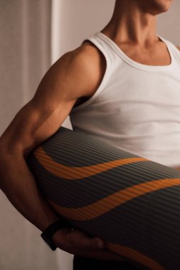 Spor koçu, elinde yoga minderi tutuyor. Yüksek kalite fotoğraf