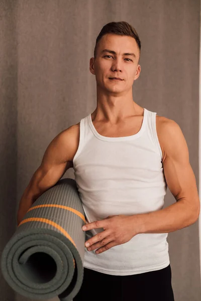 一名男子体育教练手里拿着一块瑜伽垫 高质量的照片 — 图库照片