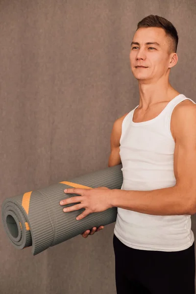 一名男子体育教练手里拿着一块瑜伽垫 高质量的照片 — 图库照片