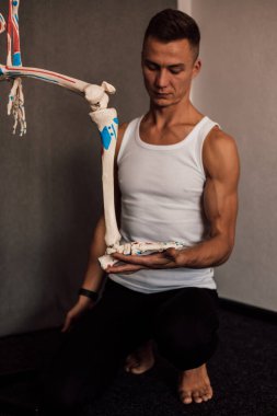 Bir adam elinde iskelet bir bacak tutar ve onu işaret eder. Yüksek kalite fotoğraf