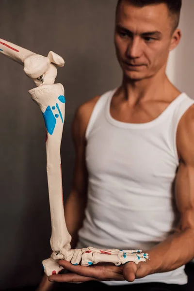 Мужчина Держит Руках Скелетную Ногу Указывает Пальцем Высокое Качество Фото — стоковое фото