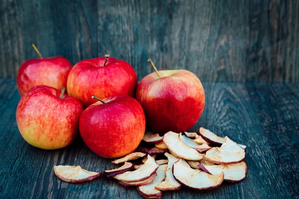Apples, dried apples and rose hips lie on a dark wooden table Autumn. High quality photo
