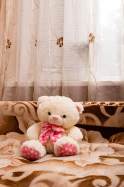 Kanepede pembe kurdeleli bir kutup ayısı. Retro tarzı. Yüksek kalite fotoğraf