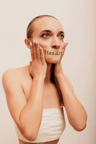 A girl with her mouth taped shut. Silence, secret. High quality photo