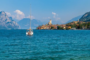 Punta San Vigilio, İtalya, sakin deniz suyu, dağlar, gökyüzü ve tekne 