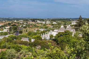 Locorotondo, İtalya - 4 Temmuz 2021: Arka planda şehir bulunan samanlıklardan oluşan sanat sergisi