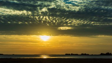Günbatımı gökyüzü ve deniz suyu yüzeyi, sakin deniz manzarası, Grado, İtalya