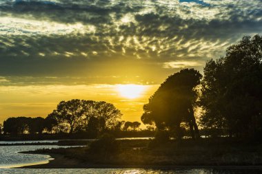 Günbatımı gökyüzü ve deniz suyu yüzeyi, sakin deniz manzarası, Grado, İtalya