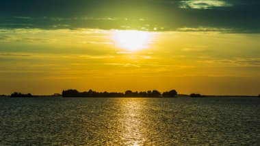 Günbatımı gökyüzü ve deniz suyu yüzeyi, sakin deniz manzarası, Grado, İtalya