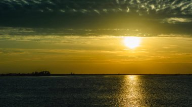 Günbatımı gökyüzü ve deniz suyu yüzeyi, sakin deniz manzarası, Grado, İtalya