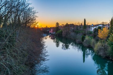 Cormons, İtalya 'da Komün, Friuli-Venezia Giulia, nehir kanalı ve ağaçlar, köyde günbatımı 